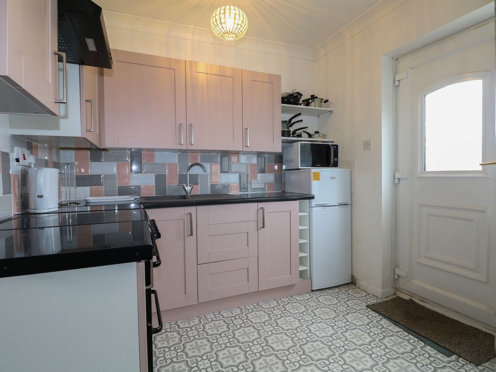 A kitchen with cabinets and appliances at 90 Bay View in New Romney