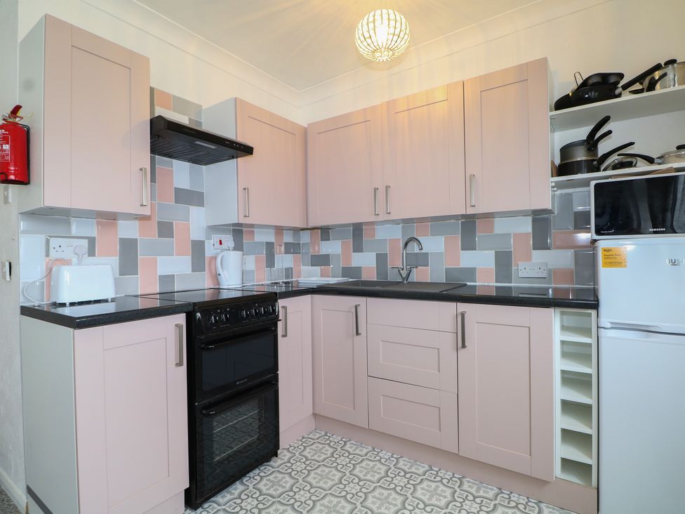 A kitchen with pink cabinets and appliances at 90 Bay View in New Romney