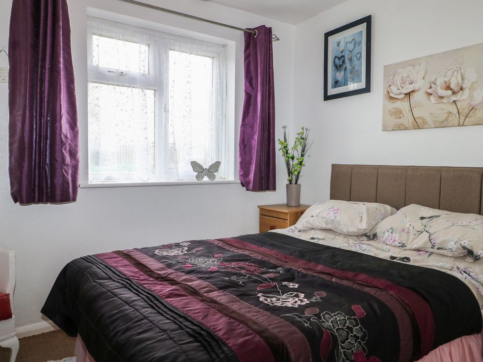 A bedroom with a bed and window at 90 Bay View in New Romney