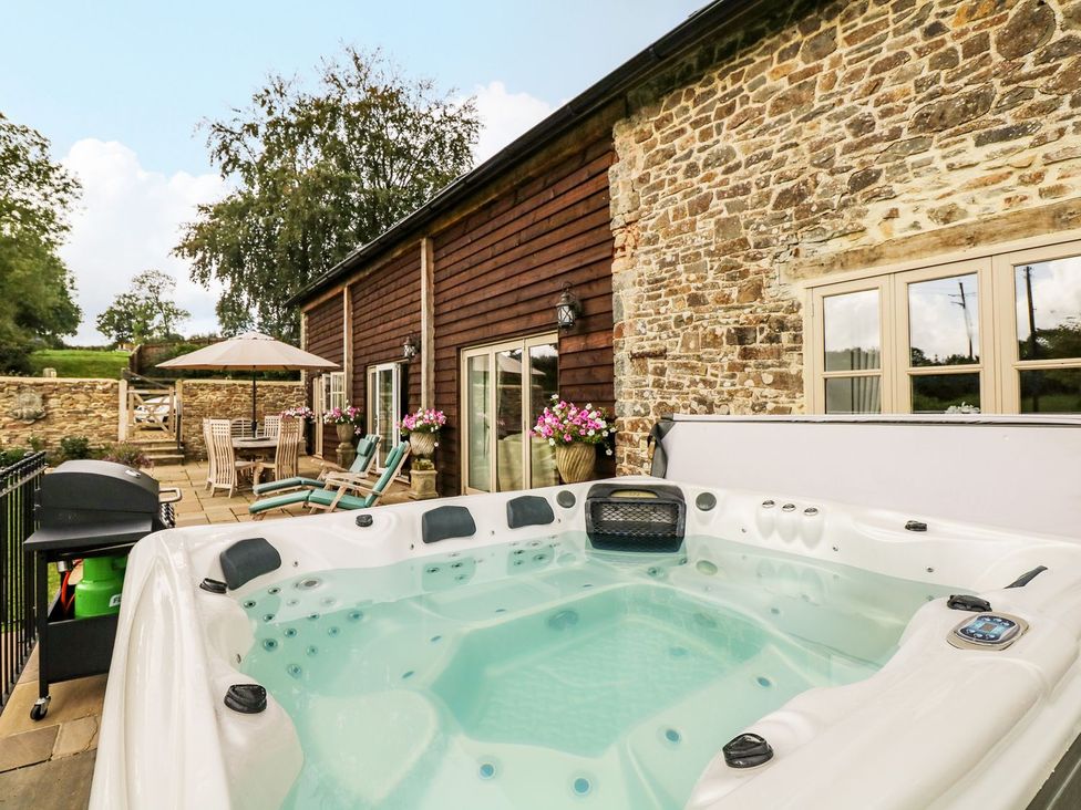 An outdoor area with a hot tub and seating at Lake View in Crediton