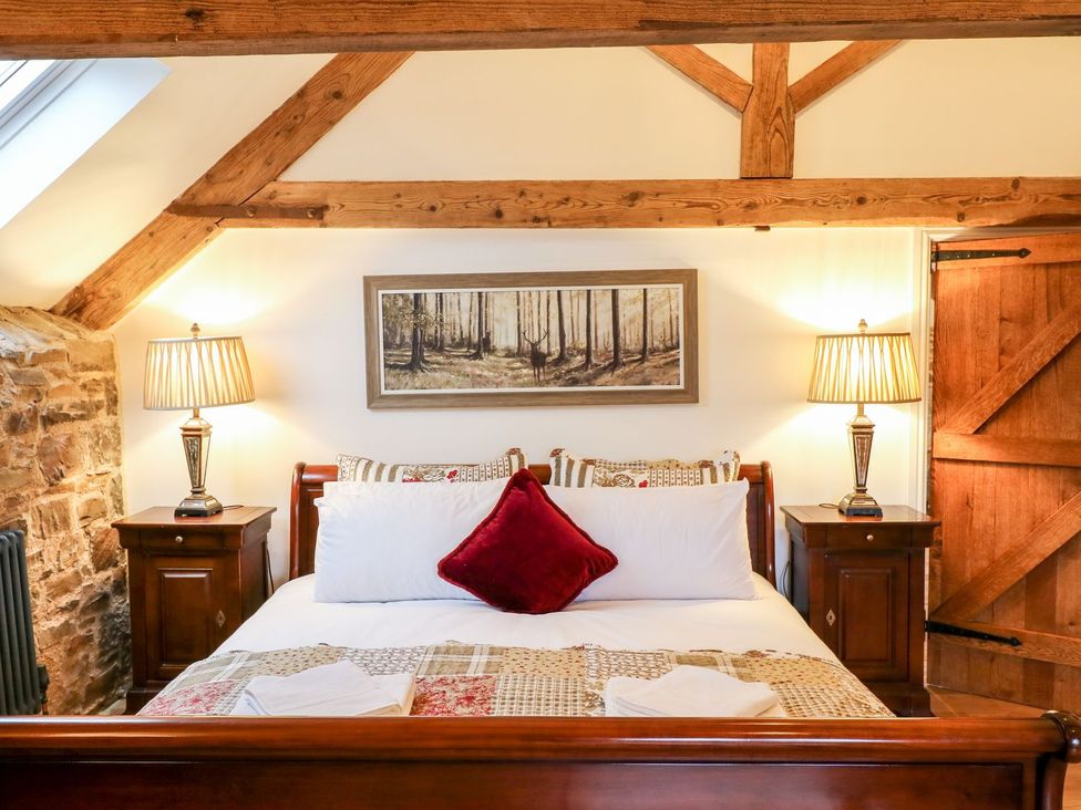 A bedroom with a bed, lamps, and a painting at Lake View in Crediton