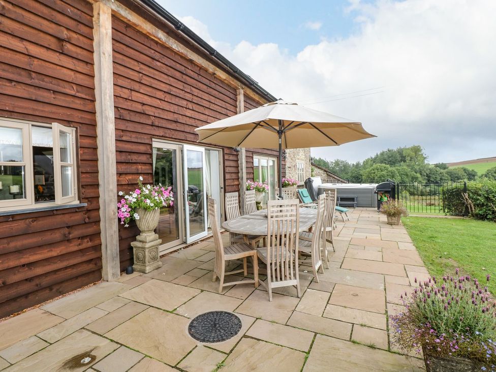 An outdoor patio with a table and chairs at Lake View in Crediton
