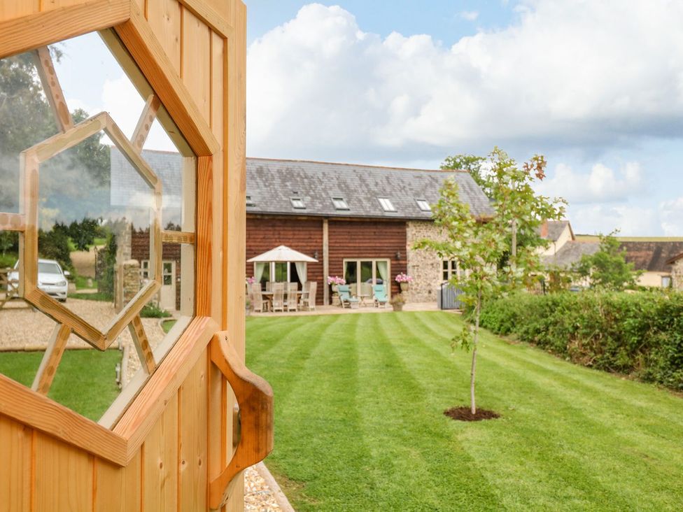 A door leading to a garden with a building in the background at Lake View in Crediton