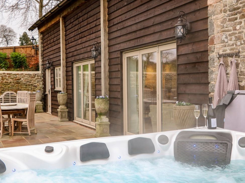 An outdoor area with a hot tub and dining table at Lake View in Crediton