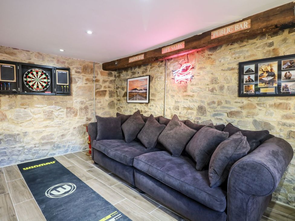 A snug with a sofa and dartboard at Lake View in Crediton