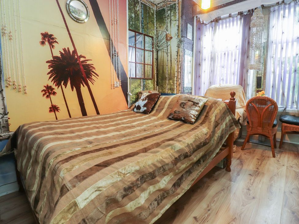 A bedroom with a bed and chairs at Number 1 in Blackpool
