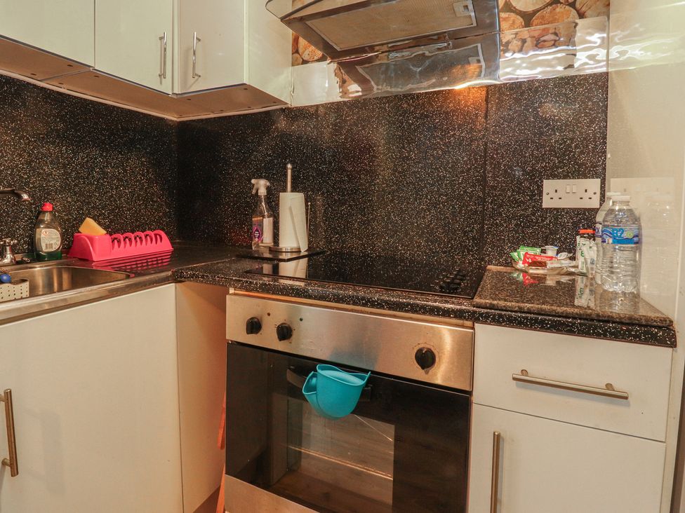 A kitchen with a sink stove and kitchen cabinet at Number 1 in Blackpool