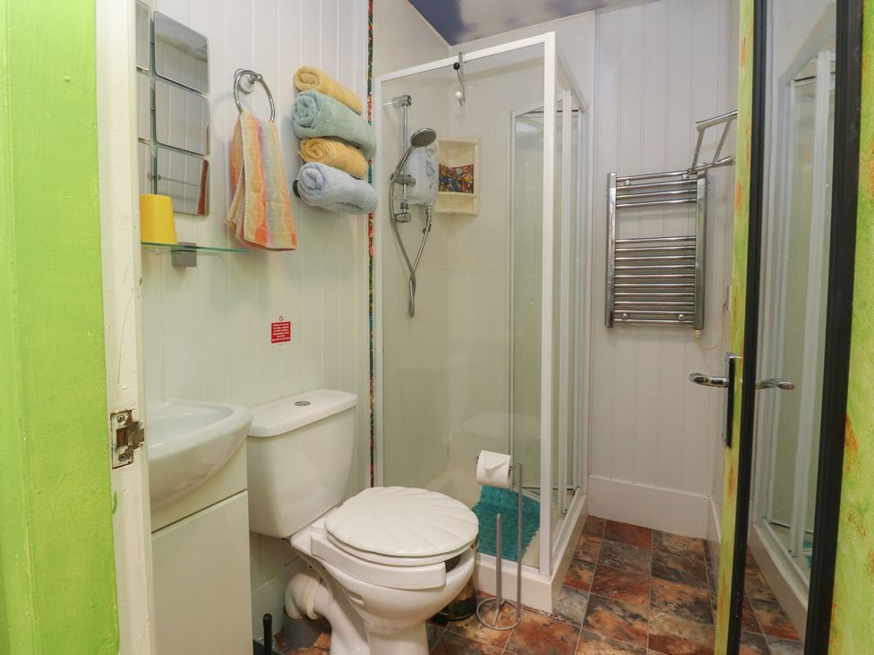 A bathroom with a shower, toilet, sink, and towels at Number 1 in Blackpool