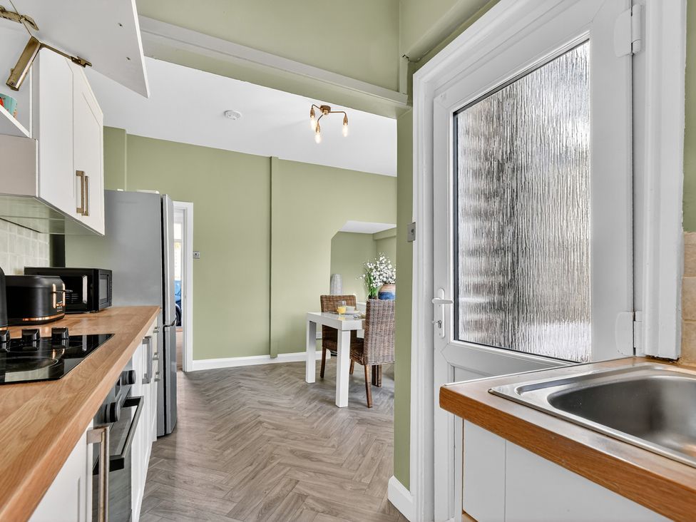 A kitchen with appliances and dining table at Windsor House in York