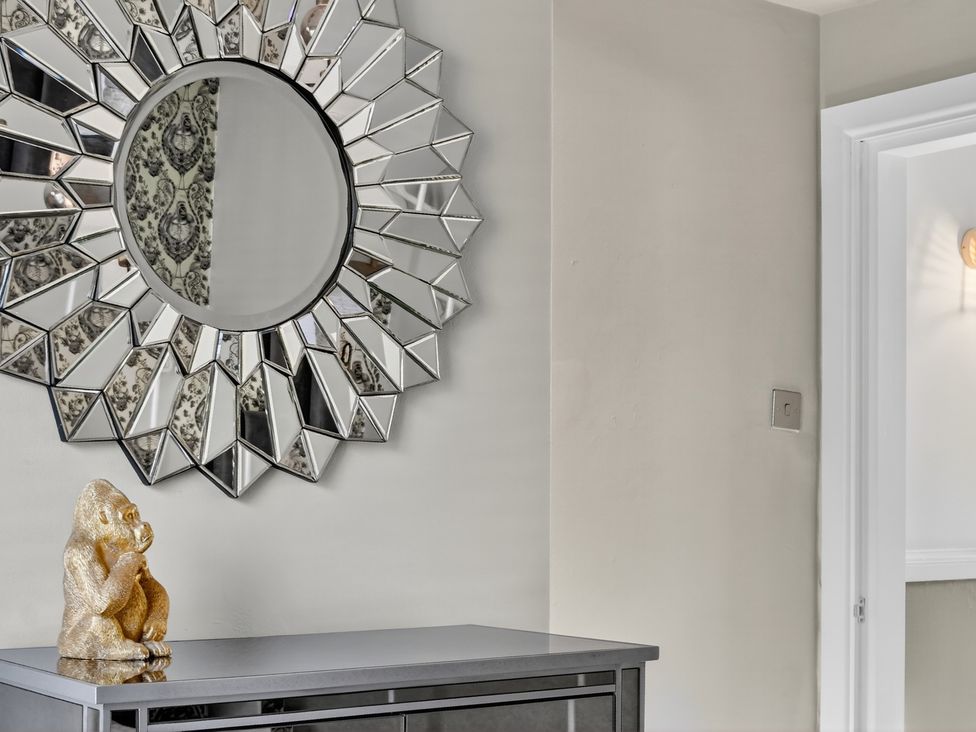 A hallway with a mirror and decorative object on a console table at Windsor House, York