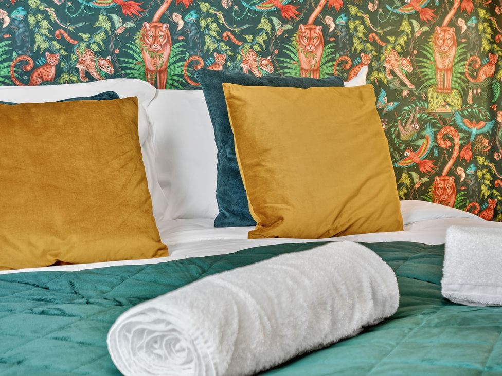 A bedroom with a bed and colorful wallpaper at Windsor House in York