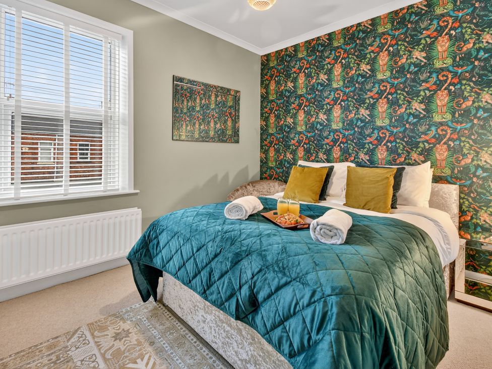 A bedroom with a bed and decorative wall at Windsor House in York