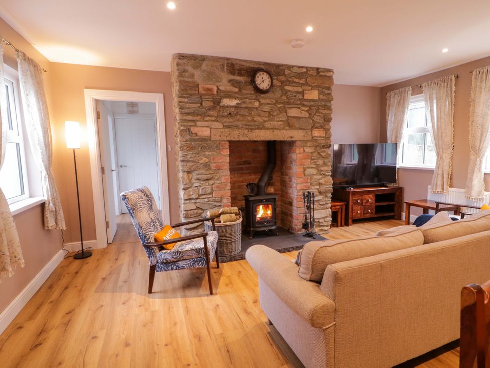 A living room with a fireplace and sofa at Annie’s Farm Cottage