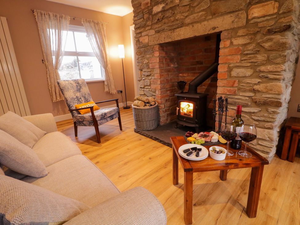 A living room with a fireplace and seating at Annie’s Farm Cottage