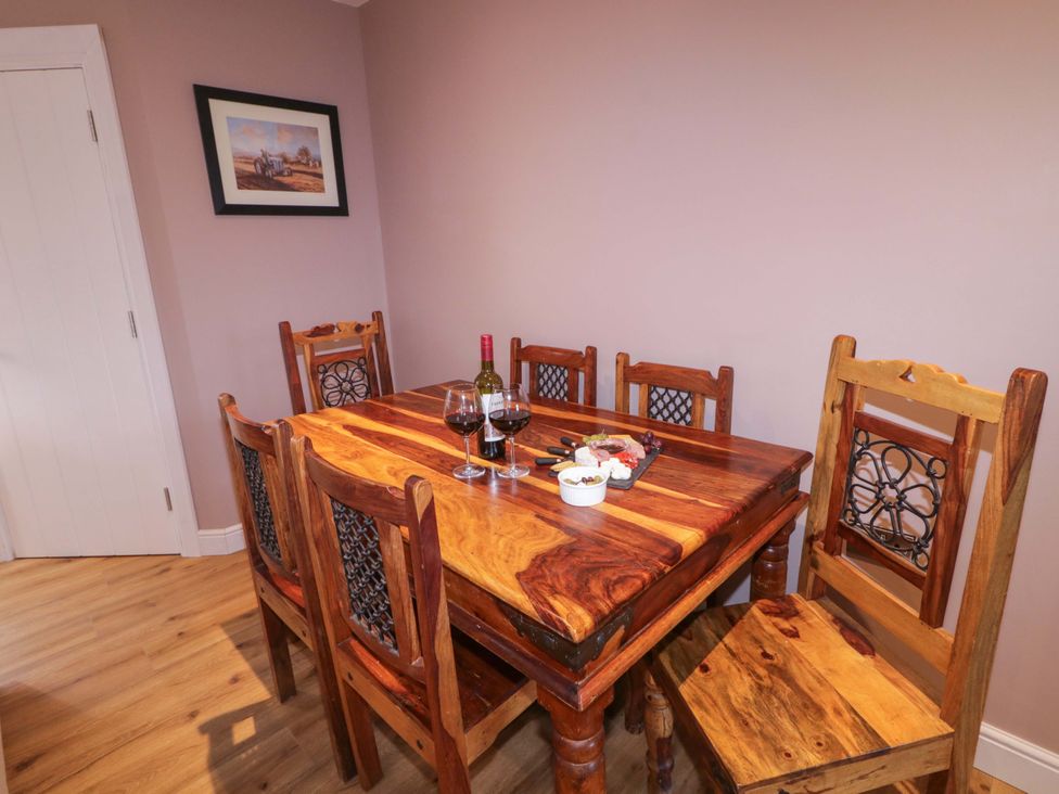 A dining room with a wooden table and chairs at Annie’s Farm Cottage