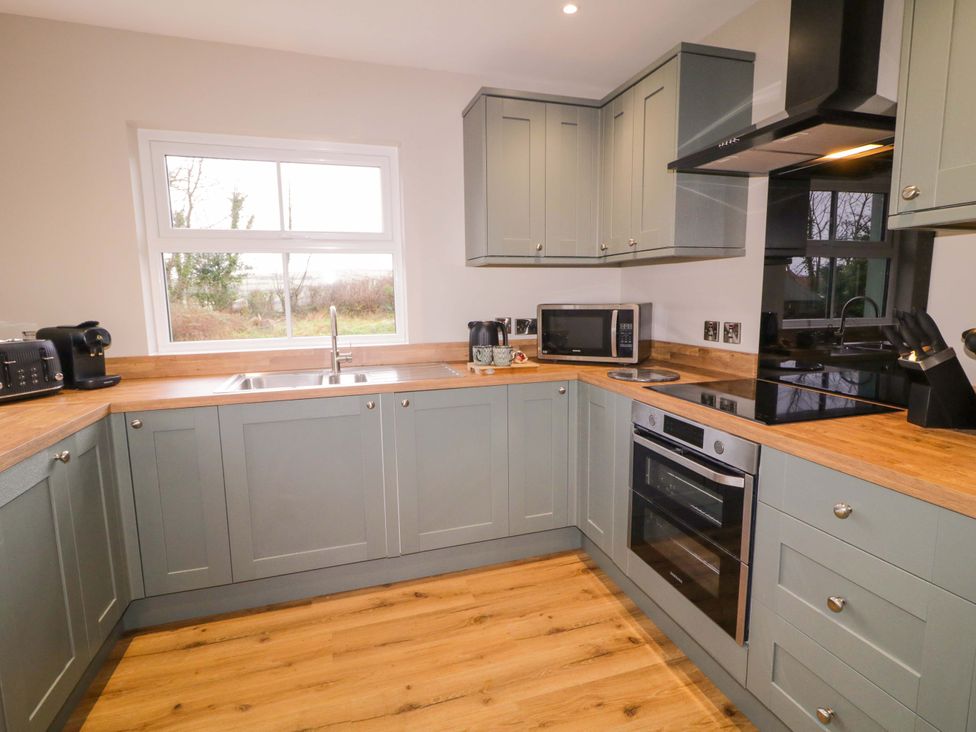 A kitchen with cabinets, sink, and appliances at Annie’s Farm Cottage