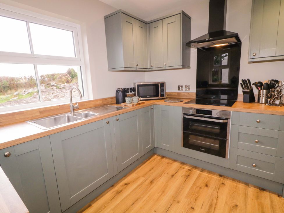 A kitchen with a sink, oven, and microwave at Annie’s Farm Cottage