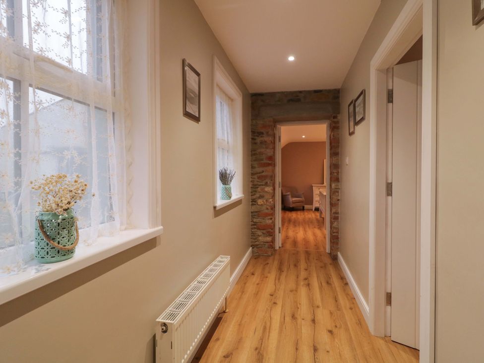A hallway with windows and a radiator at Annie’s Farm Cottage