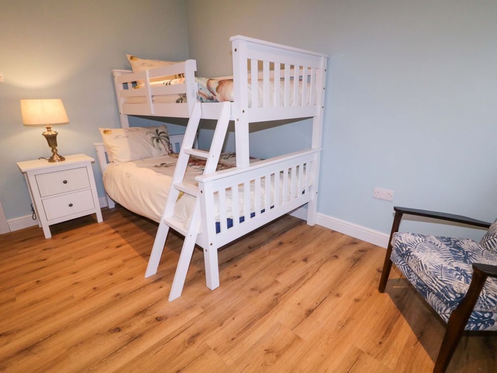 A bedroom with a bunk bed and a single bed at Annie’s Farm Cottage