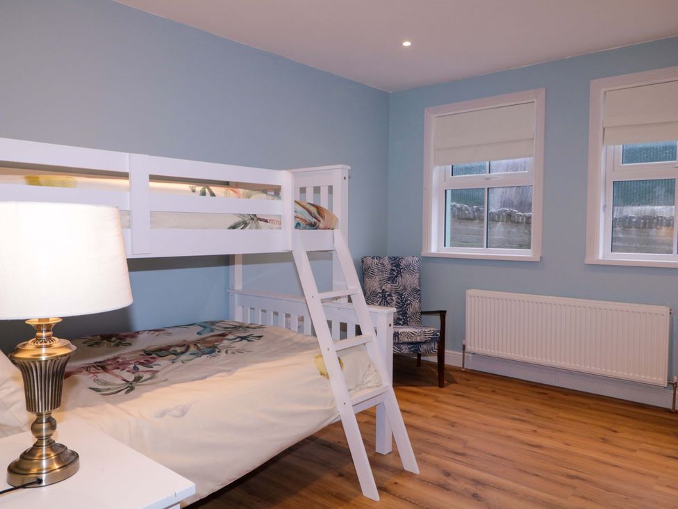 A bedroom with a bunk bed and chair at Annie’s Farm Cottage