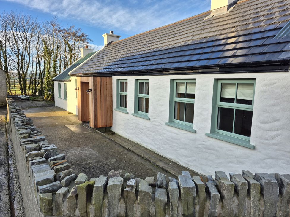 A house with a stone wall and pathway at Annie’s Farm Cottage Near Londonderry, Northern Ireland