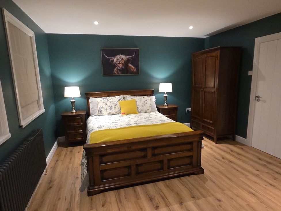 A bedroom with a bed and a wardrobe at Annie’s Farm Cottage Near Londonderry Northern Ireland