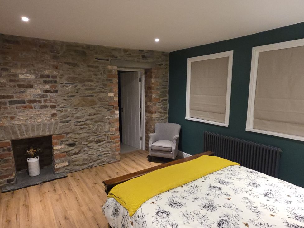 A bedroom with a bed and a chair at Annie’s Farm Cottage Near Londonderry, Northern Ireland