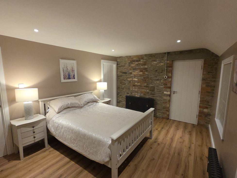 A bedroom with a bed and nightstands at Annie’s Farm Cottage near Londonderry, Northern Ireland