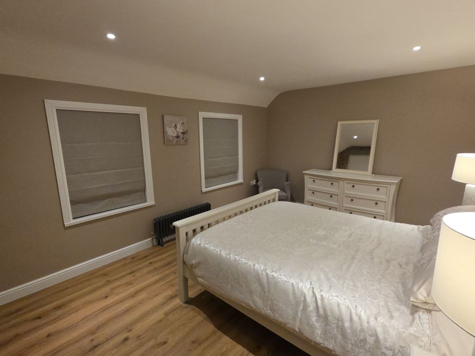 A bedroom with a bed and a dressing table at Annie’s Farm Cottage Near Londonderry, Northern Ireland