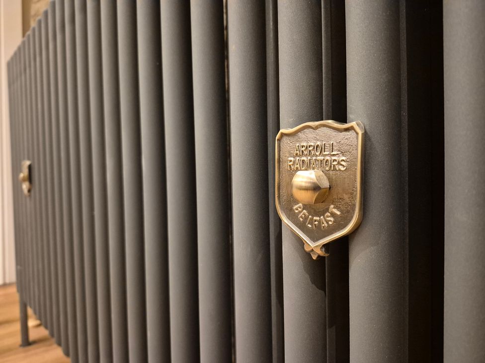 A close-up of a radiator with a brass valve and plaque at Annie’s Farm Cottage near Londonderry, Northern Ireland