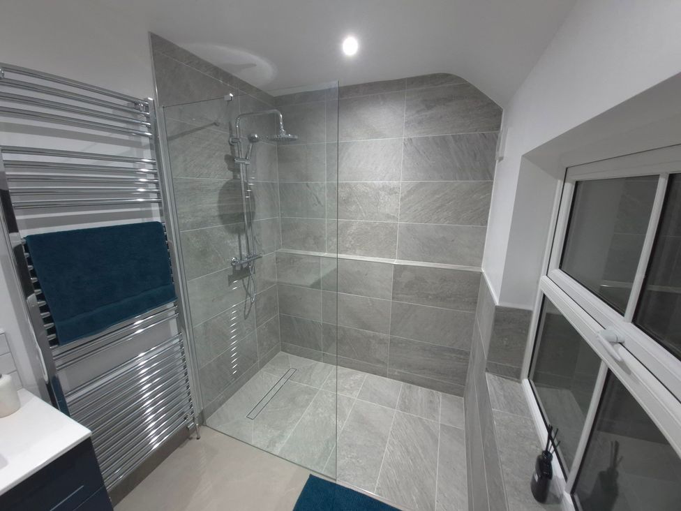 A bathroom with a shower and towel rail at Annie’s Farm Cottage Near Londonderry, Northern Ireland