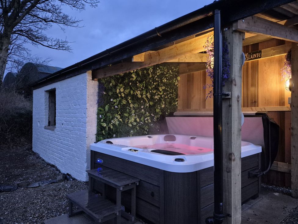 A hot tub with steps beside a wooden structure at Annie’s Farm Cottage near Londonderry, Northern Ireland