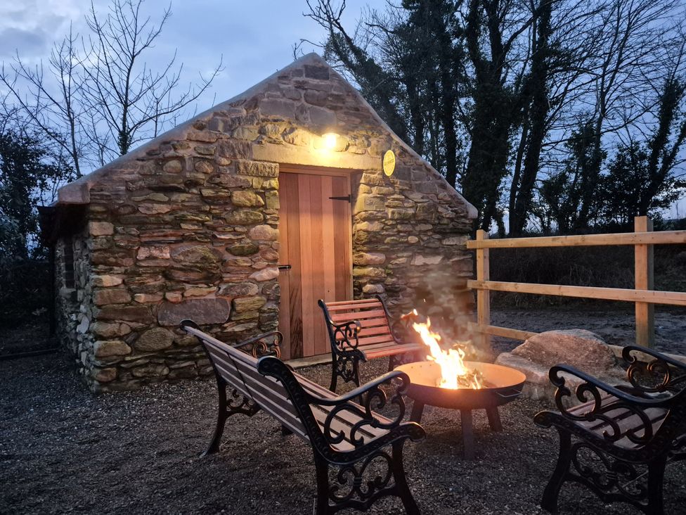 An outdoor area with a stone building and fire pit at Annie’s Farm Cottage Near Londonderry, Northern Ireland