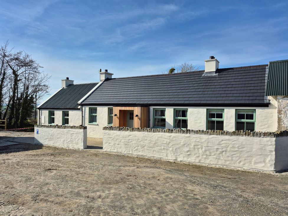 A house with a stone wall and windows at Annie’s Farm Cottage Near Londonderry, Northern Ireland