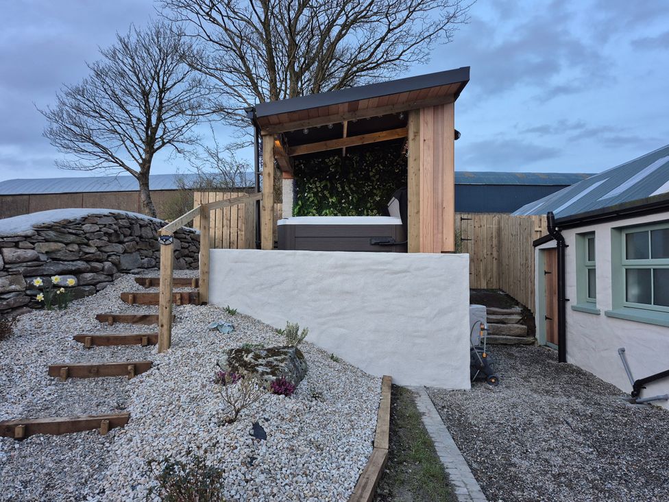A hot tub in a wooden structure with steps in the outdoor area at Annie’s Farm Cottage Near Londonderry, Northern Ireland