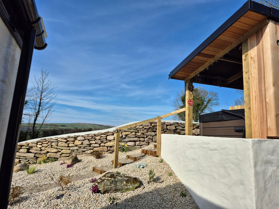 An outdoor area with a hot tub and stone wall at Annie’s Farm Cottage Near Londonderry, Northern Ireland
