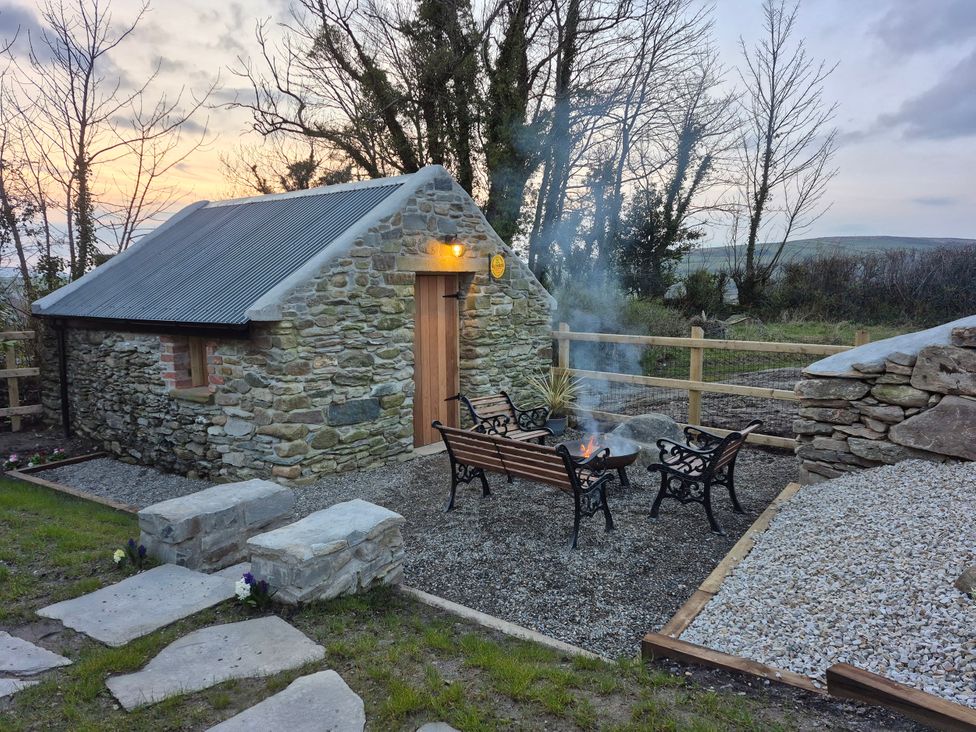 An outdoor area with a stone building and fire pit at Annie’s Farm Cottage near Londonderry, Northern Ireland
