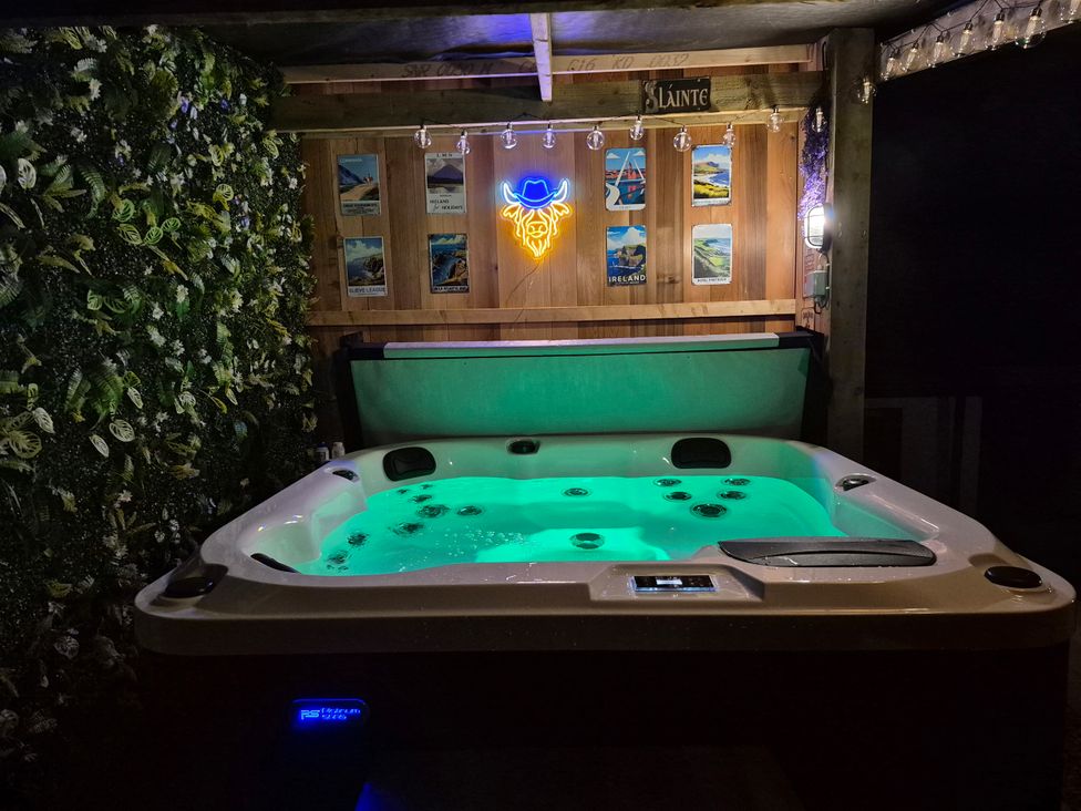 A hot tub with glowing water in an outdoor area at Annie’s Farm Cottage near Londonderry, Northern Ireland