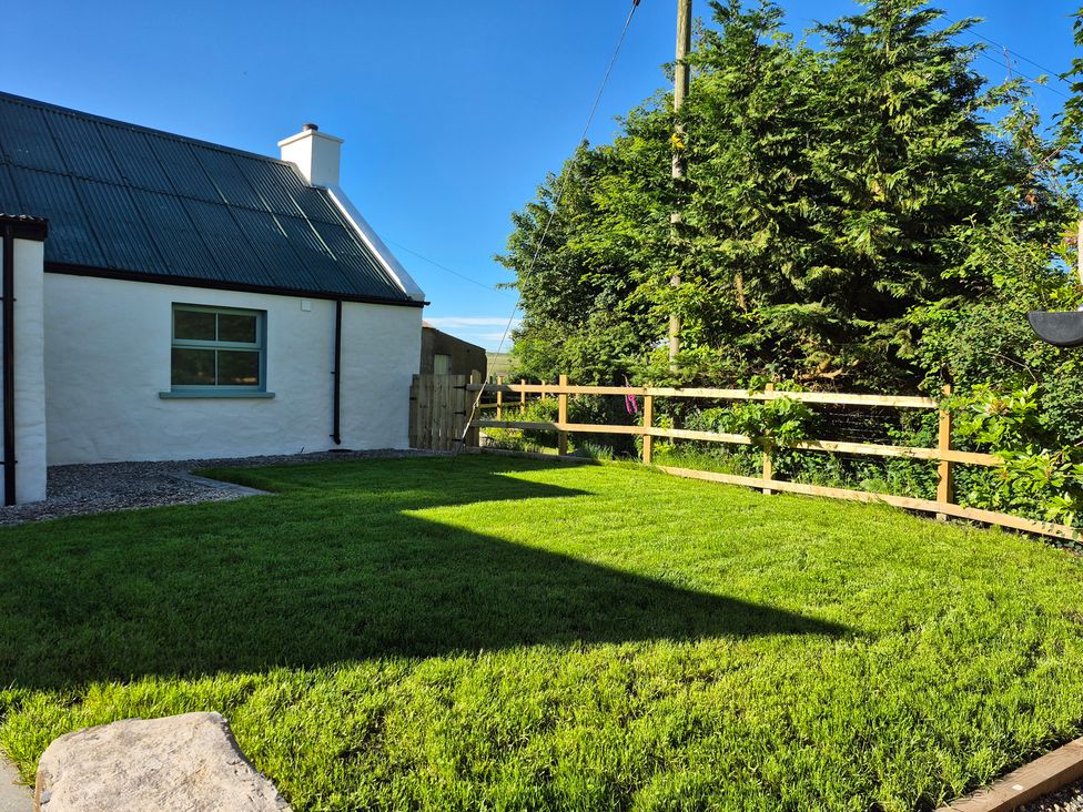 A garden with grass and a fence at Annie’s Farm Cottage near Londonderry, Northern Ireland