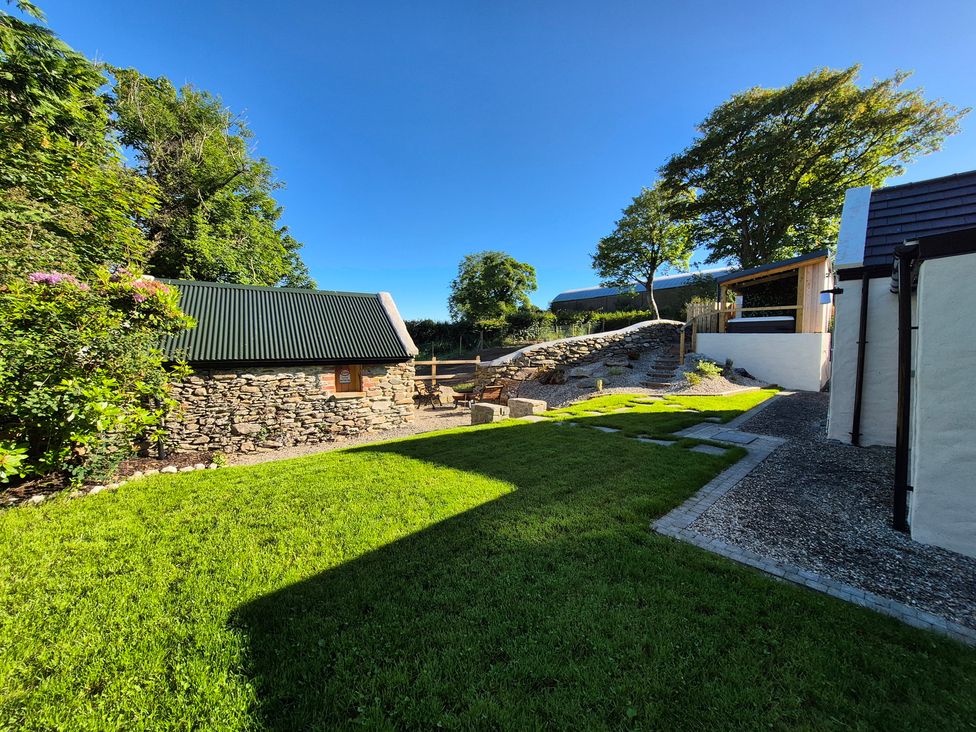 An outdoor area with a grass lawn and stone path at Annie’s Farm Cottage near Londonderry, Northern Ireland