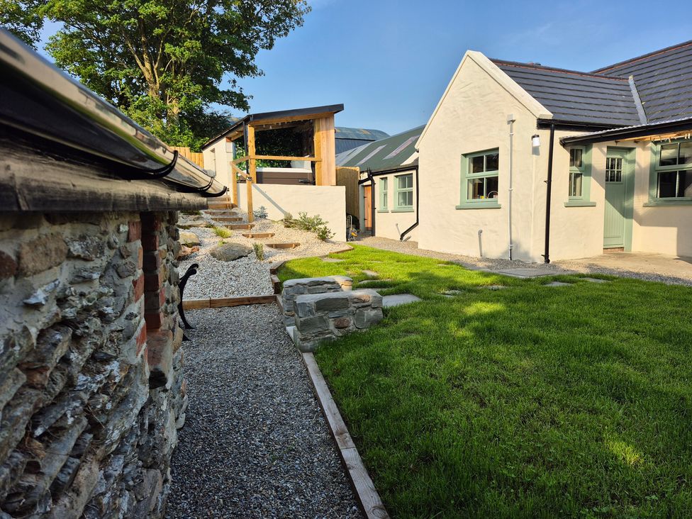 An outdoor area with a stone wall and gravel path at Annie’s Farm Cottage near Londonderry, Northern Ireland