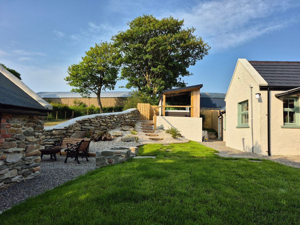 A garden with a stone wall and steps at Annie’s Farm Cottage near Londonderry, Northern Ireland