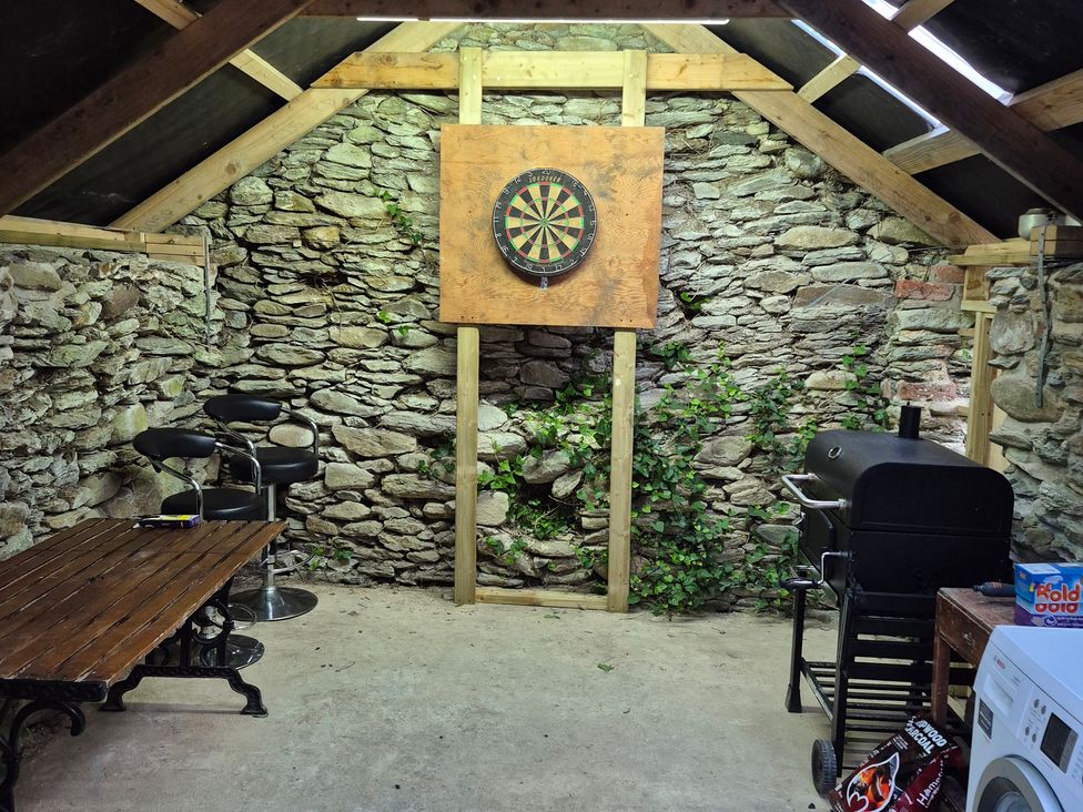 A snug with a dartboard and seating at Annie’s Farm Cottage near Londonderry, Northern Ireland