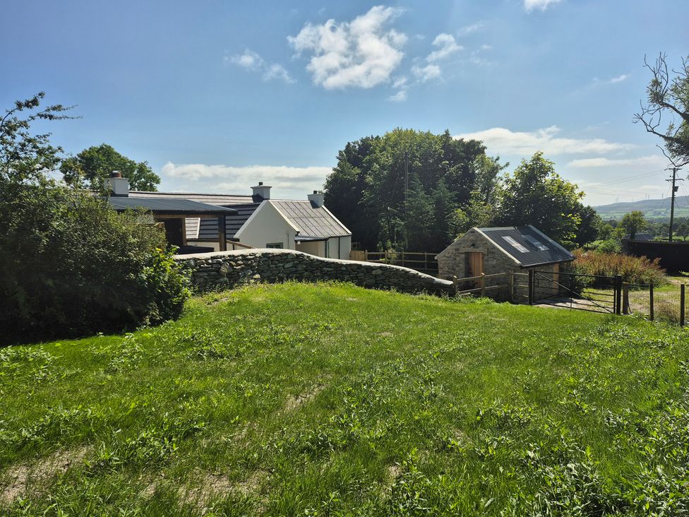 An outdoor area showcasing a house and a shed at Annie’s Farm Cottage near Londonderry, Northern Ireland