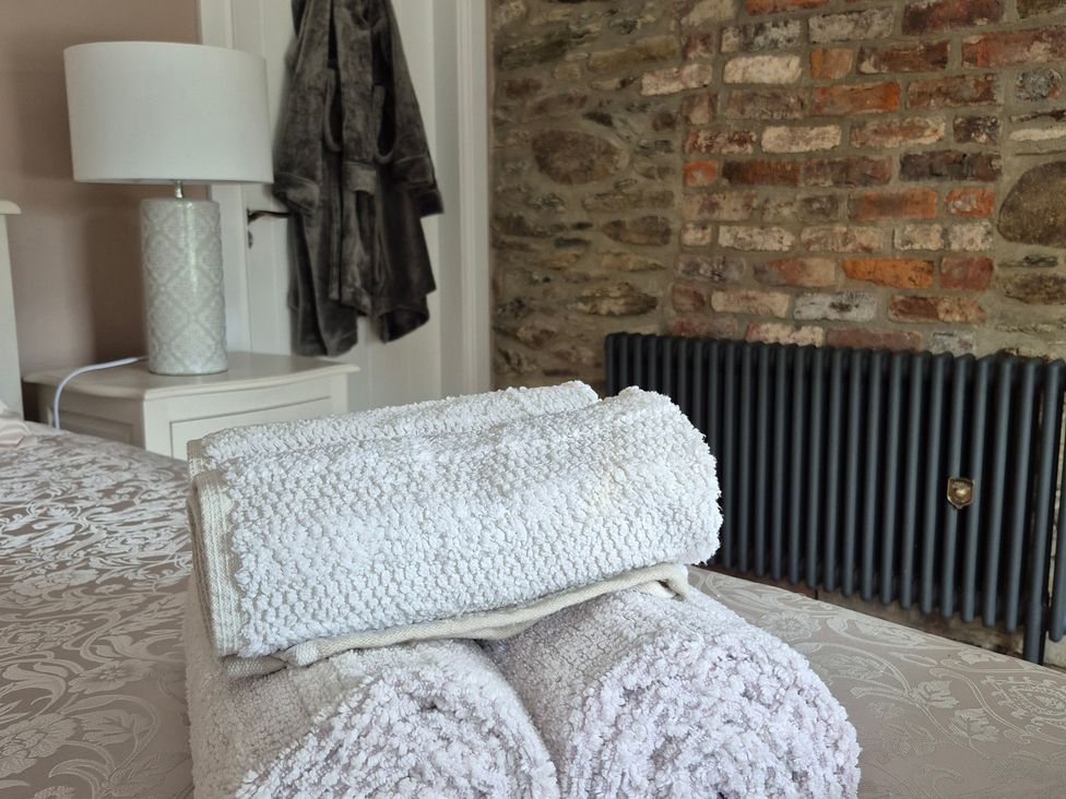 A bedroom with folded towels and a lamp at Annie’s Farm Cottage near Londonderry, Northern Ireland