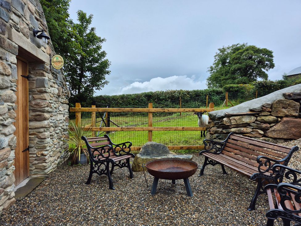 An outdoor seating area with a fire pit and benches at Annie’s Farm Cottage Near Londonderry, Northern Ireland