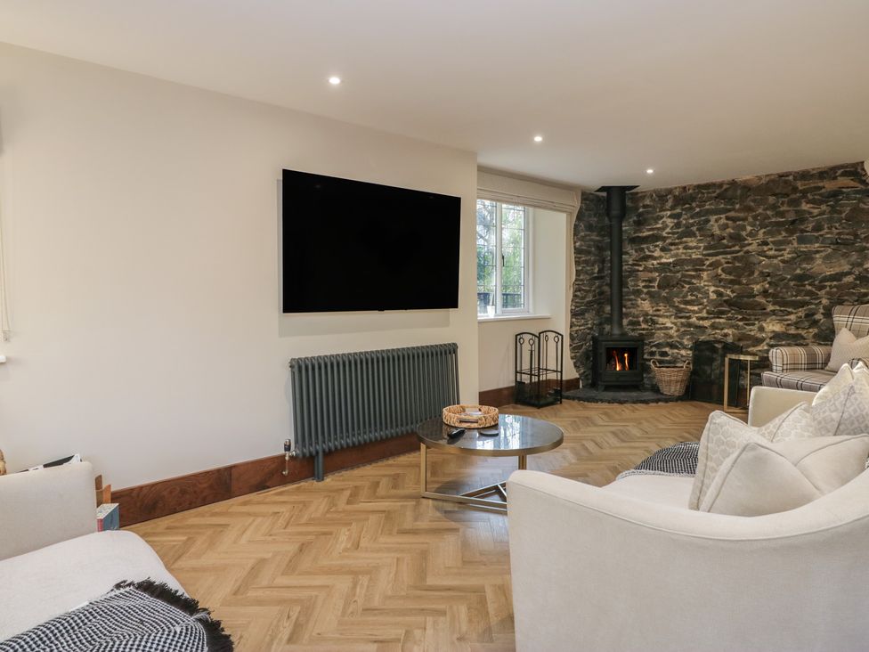 A living room with a television and a fireplace at North Cottage in Bowness-On-Windermere
