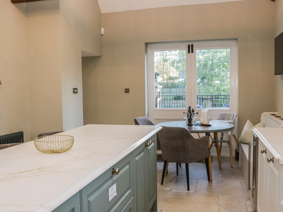 A kitchen with a table and chairs beside a window at North Cottage Bowness-On-Windermere
