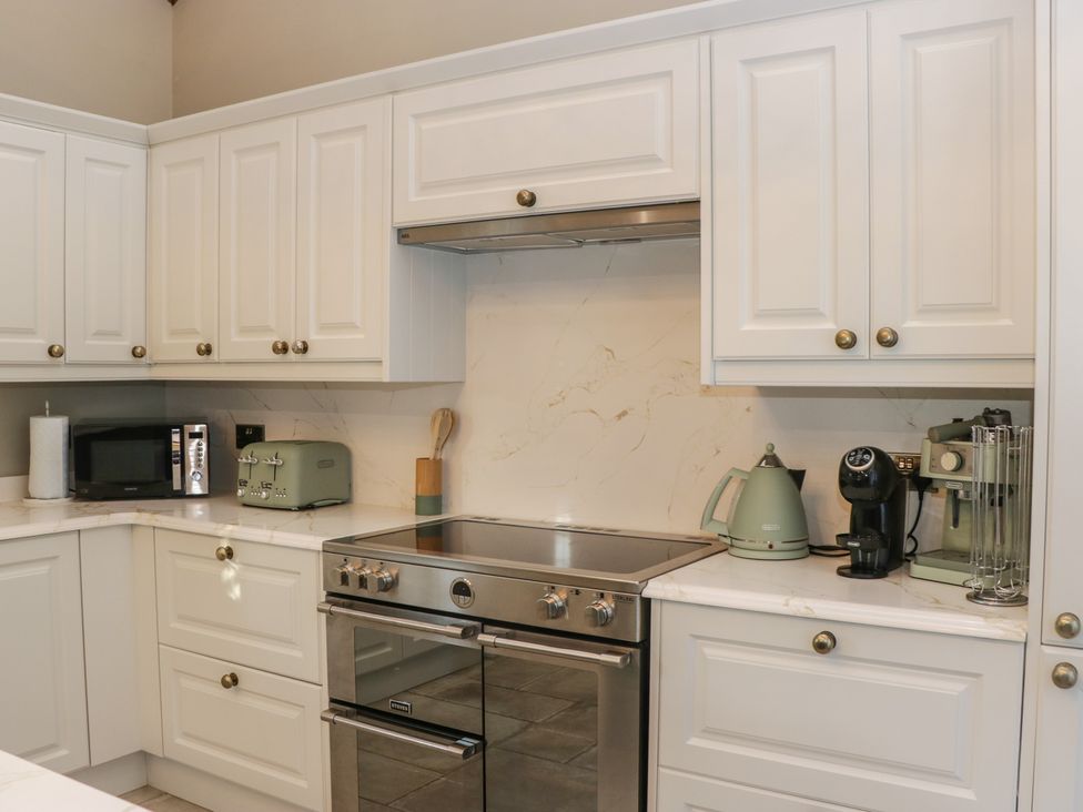 A kitchen with an oven and microwave at North Cottage in Bowness-On-Windermere