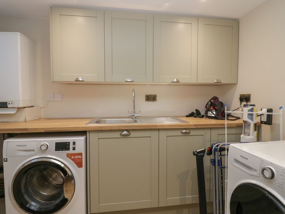 A utility room with a washing machine and sink at North Cottage in Bowness-On-Windermere